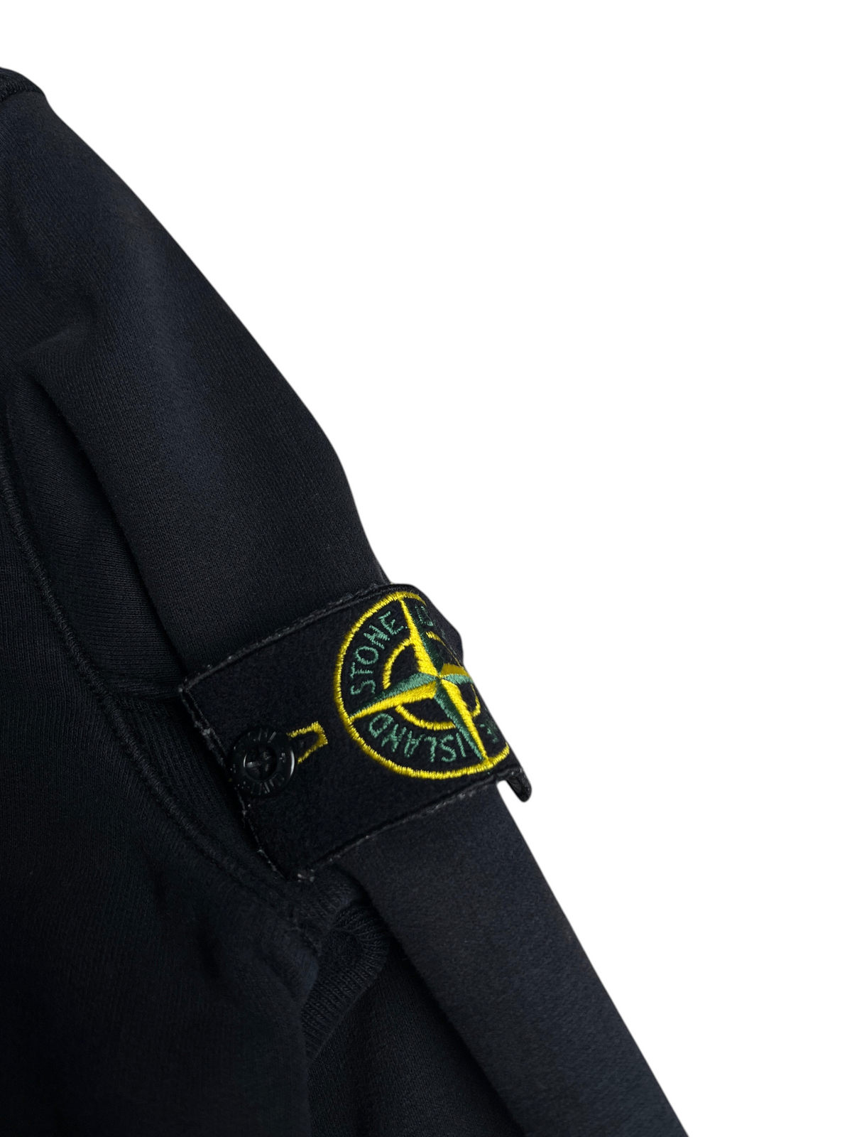 Badge logo Stone Island noir sur la manche d'un sweat à capuche vinqo.store