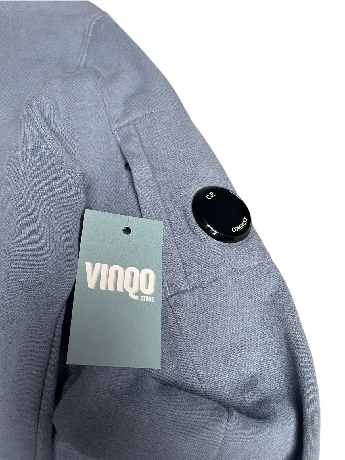 Sweat bleu C.P. Company avec poche sur la manche et logo emblématique, disponible chez vinqo.store