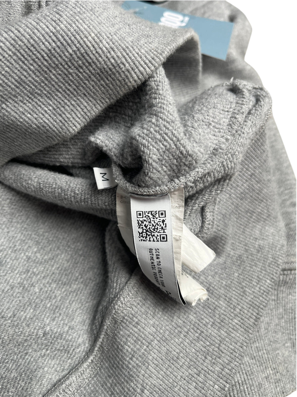 Étiquette intérieure avec code QR d'authenticité sur un sweat à capuche gris vinqo.store en taille M