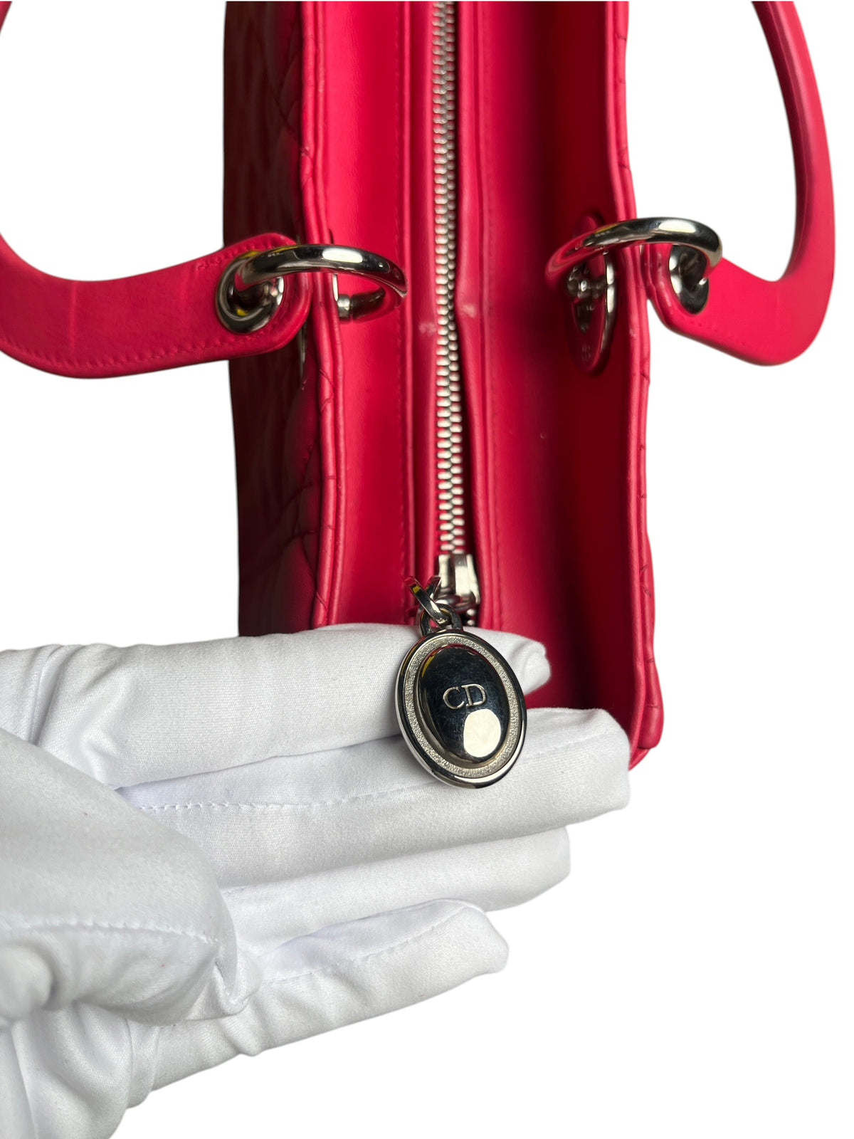 Détail du fermoir zippé argenté avec logo CD sur un sac Lady Dior Large rose fuchsia de vinqo.store