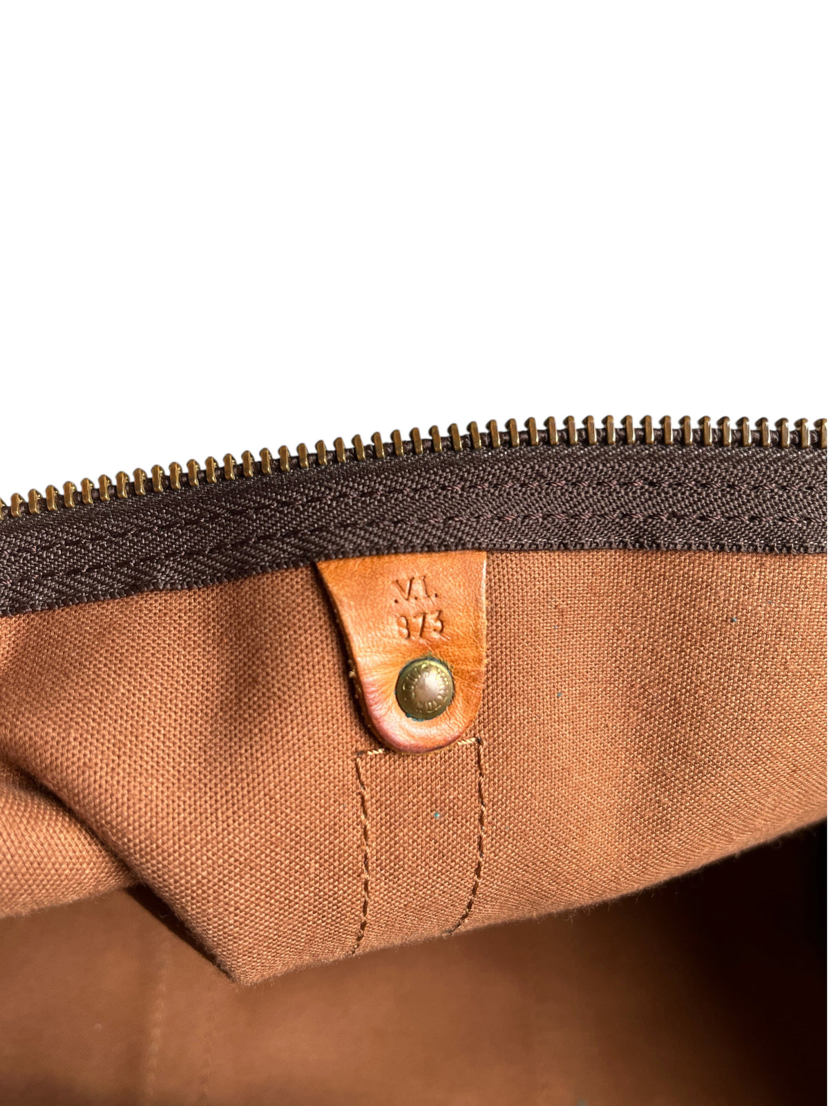 Détail intérieur du sac vinqo.store Louis Vuitton Keepall 55 avec étiquette en cuir et code date gravé