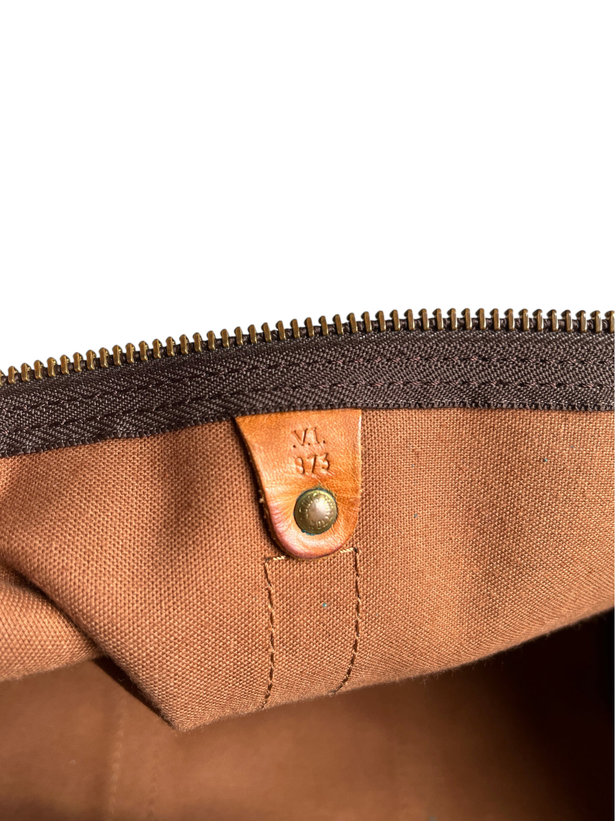 Détail intérieur du sac vinqo.store Louis Vuitton Keepall 55 avec étiquette en cuir et code date gravé