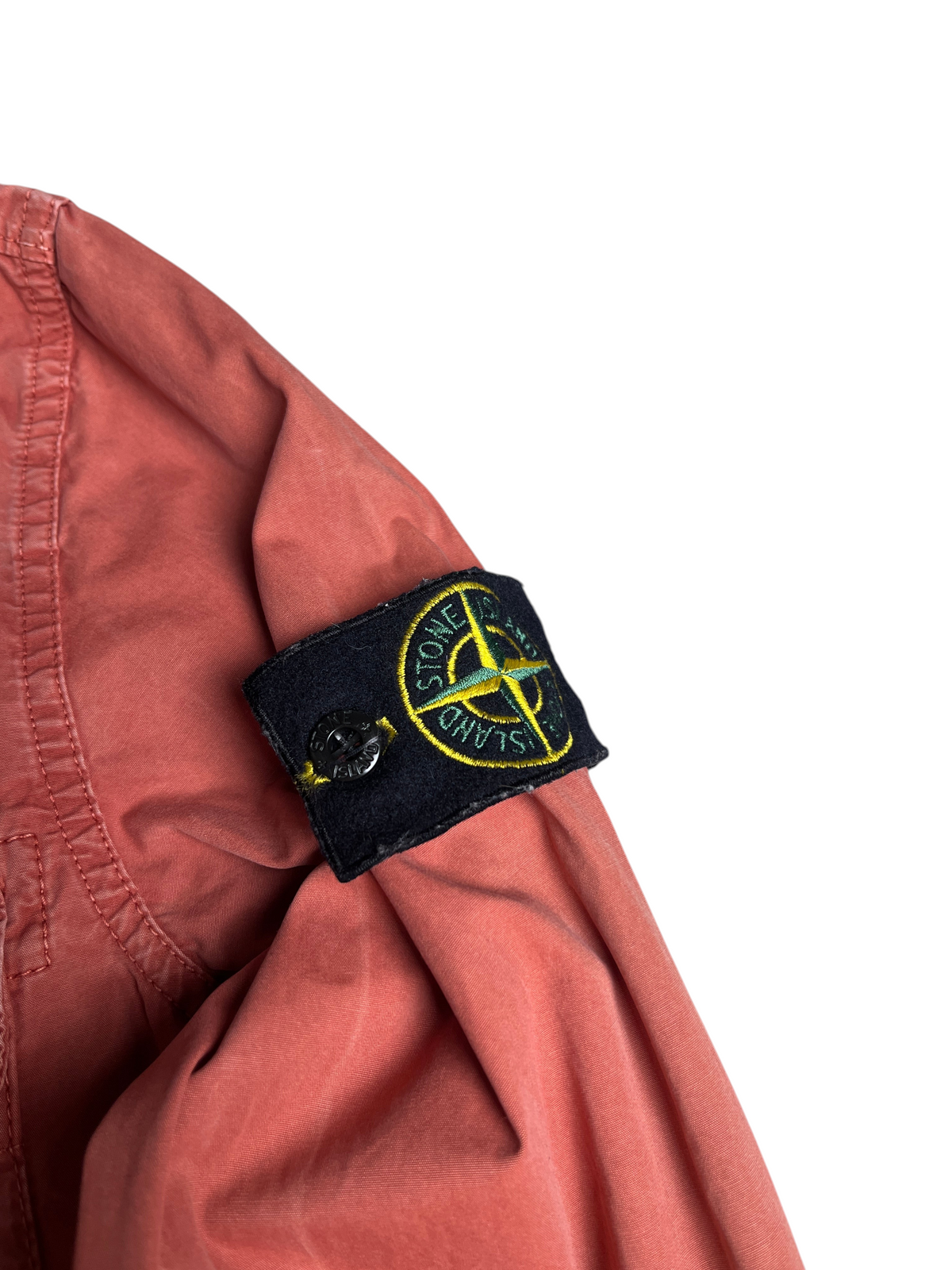 Surchemise vintage vinqo.store rouge délavé avec écusson Stone Island emblématique sur la manche