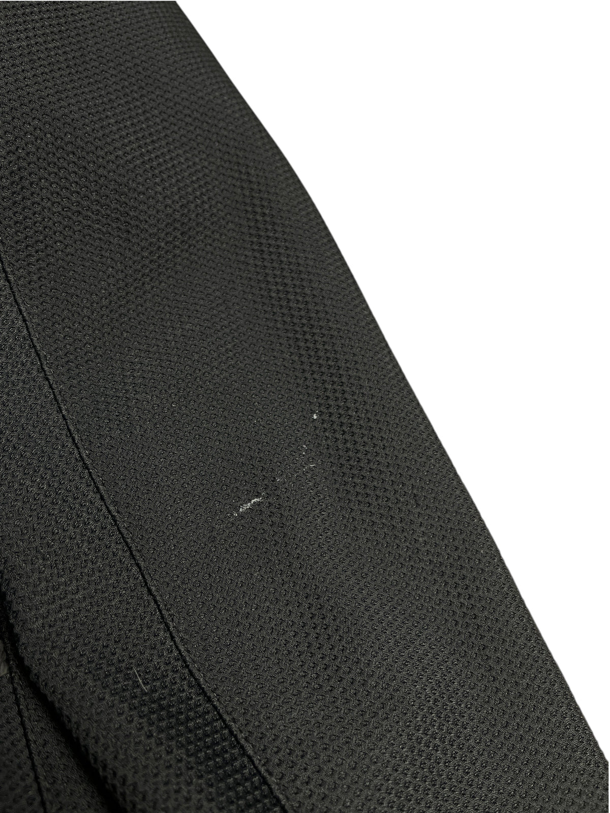 Gros plan sur le tissu noir texturé de la veste Parajumpers Warmup de vinqo.store montrant un léger défaut d'usure.