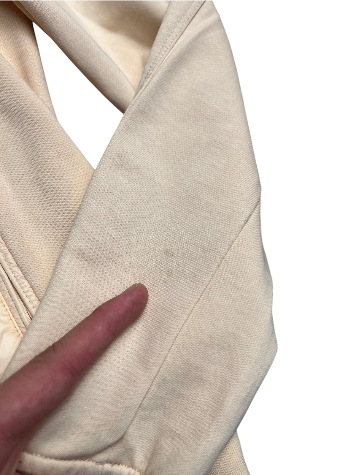 Détail d'une veste vinqo.store beige montrant une légère tache sur la manche