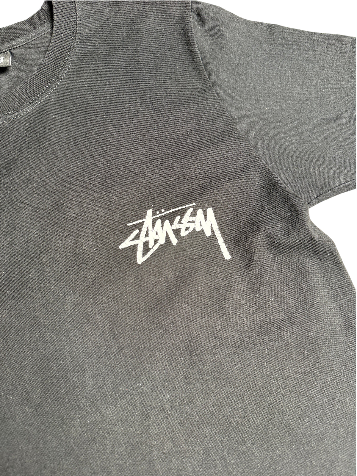 T-shirt noir Stussy de vinqo.store avec logo blanc imprimé sur la poitrine, style vintage en coton