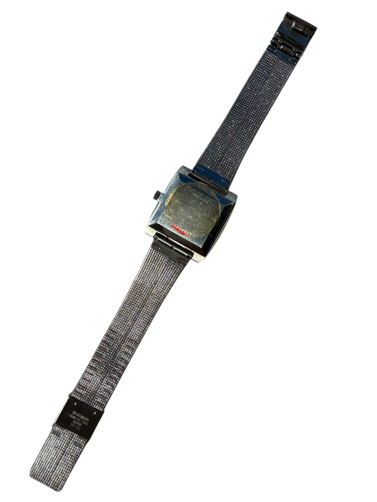 Dos de la montre vintage vinqo.store Longines Conquest 1975 avec bracelet en maille milanaise et sticker d'origine