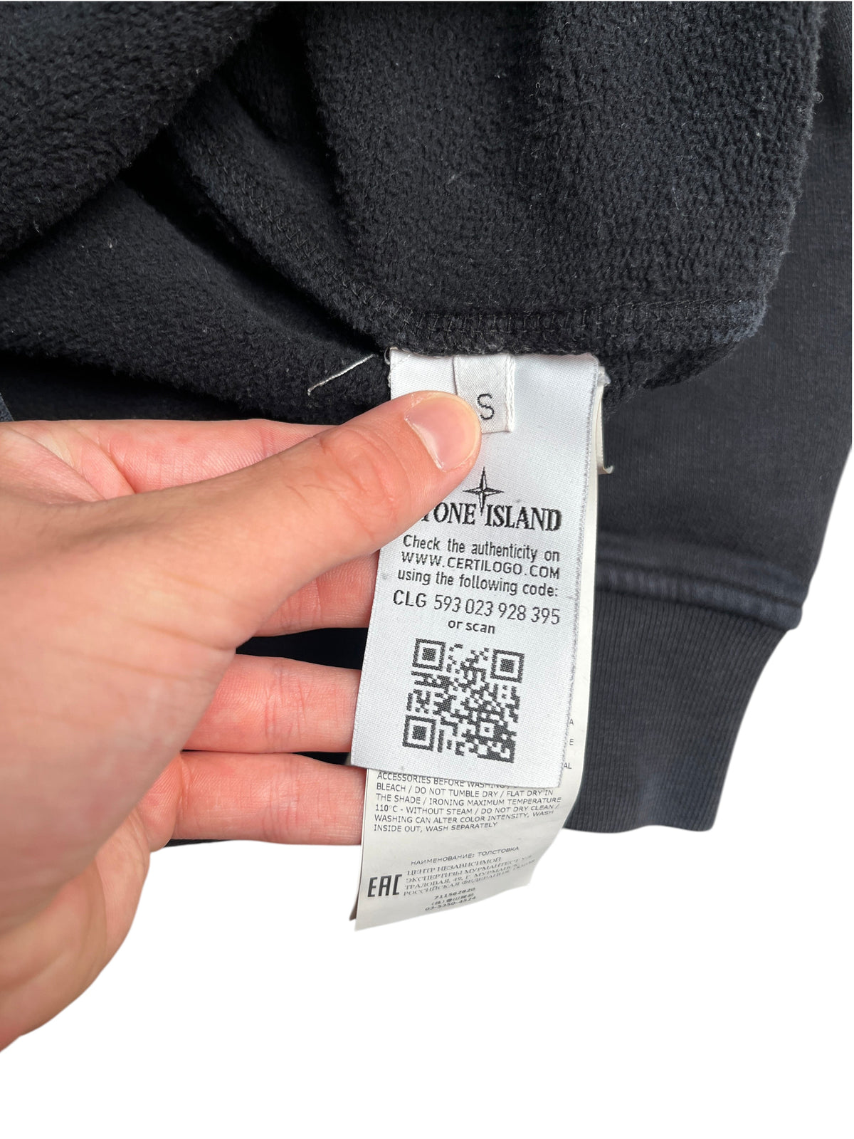 Étiquette intérieure d'authenticité avec code QR et logo Stone Island sur un sweat à capuche noir vinqo.store
