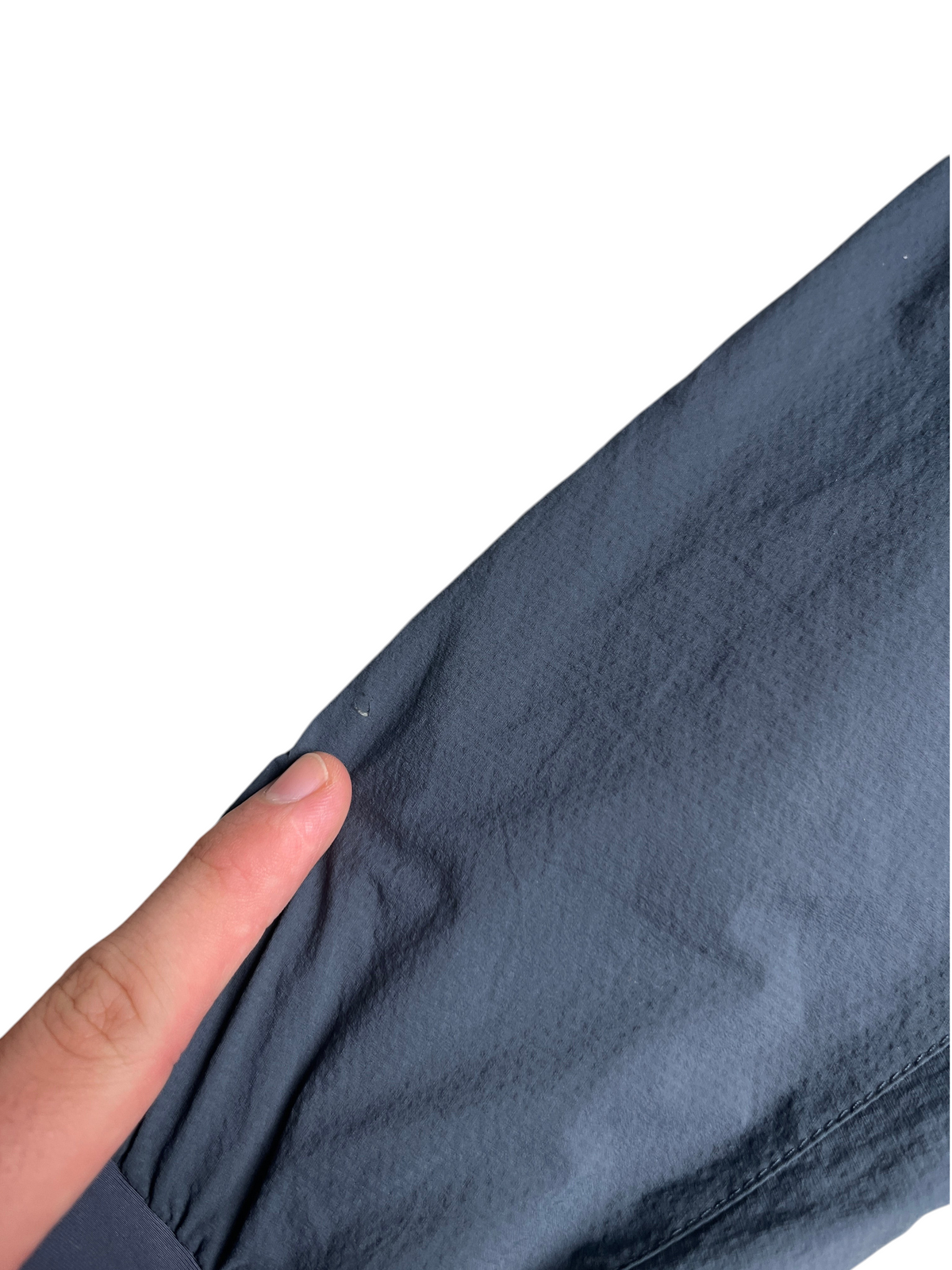 Gros plan sur un petit défaut sur la manche grise d'une veste Arc'teryx Atom LT chez vinqo.store