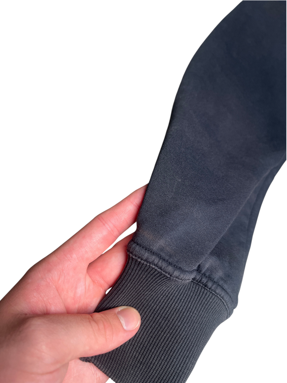 Gros plan sur la manche en polaire noire de la veste vinqo.store montrant une légère décoloration sur le tissu