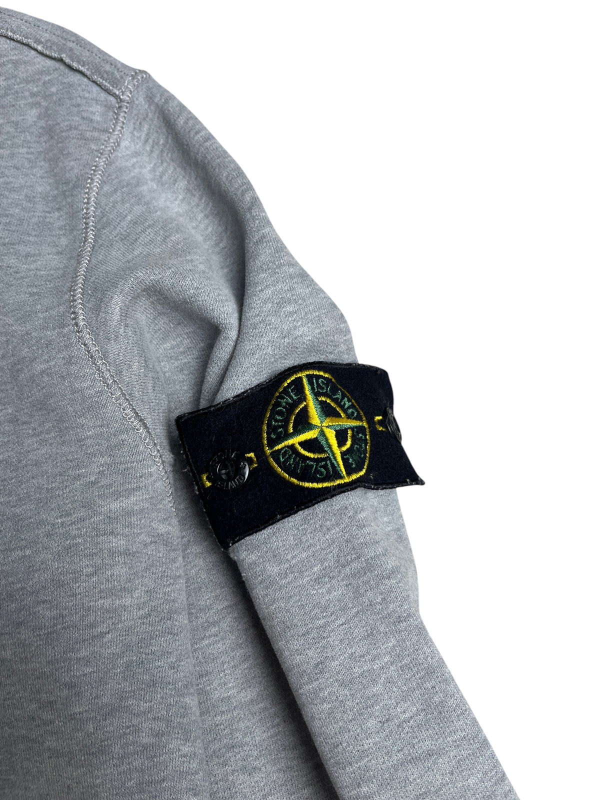 Sweat-shirt gris Stone Island de vinqo.store avec l'écusson emblématique sur la manche
