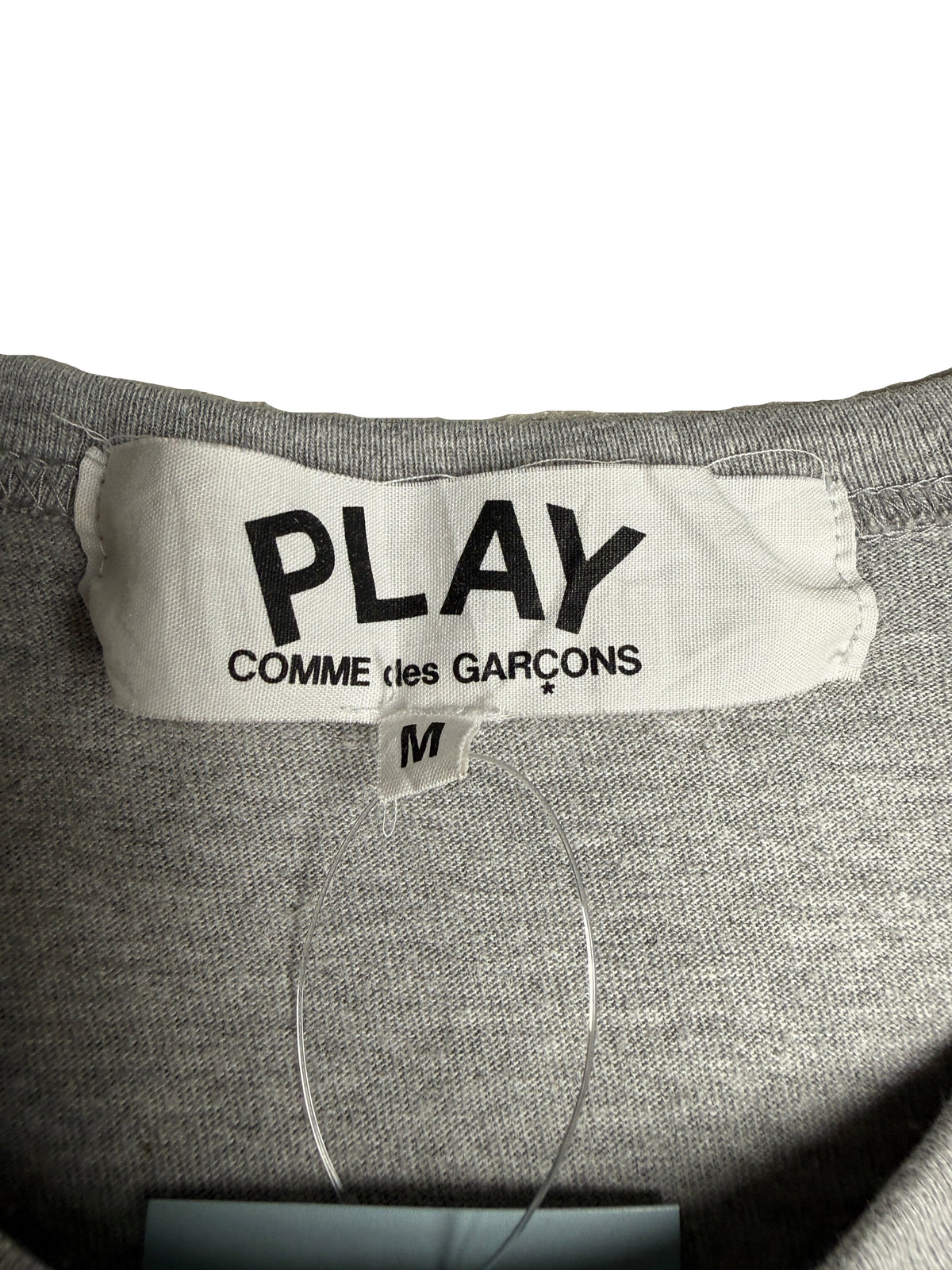 Étiquette de col grise d'un t-shirt vinqo.store PLAY COMME des GARÇONS en taille M